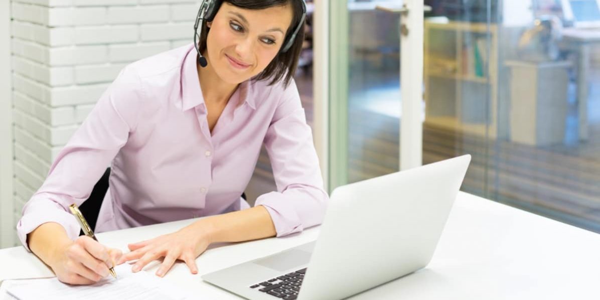 Webinar_Zeit Selbstmanagement_Juni 2017 Teilnehmerin eines Webinars mit Headset und Notizblock blickt auf ein Notebook