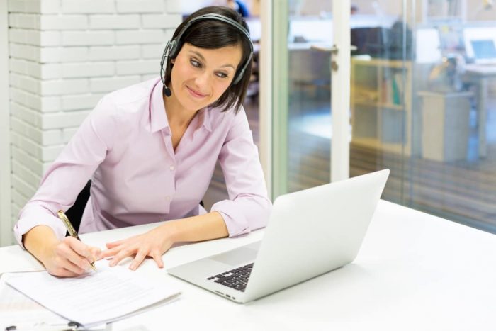 Webinar_Zeit Selbstmanagement_Juni 2017 Teilnehmerin eines Webinars mit Headset und Notizblock blickt auf ein Notebook